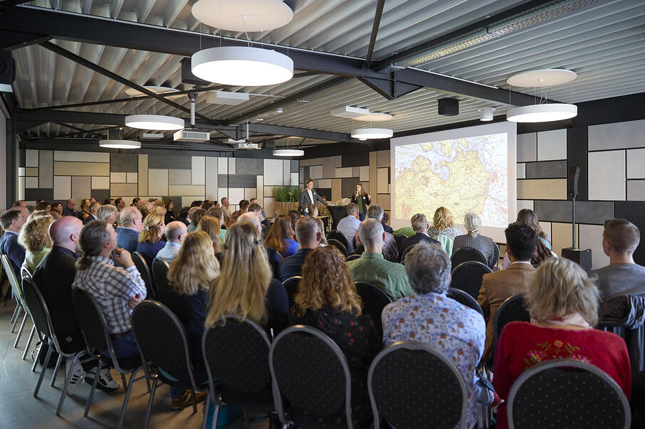 lezing met spreker en mensen in een zaal