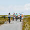 Een groep fietsers vertrekt op de dijk