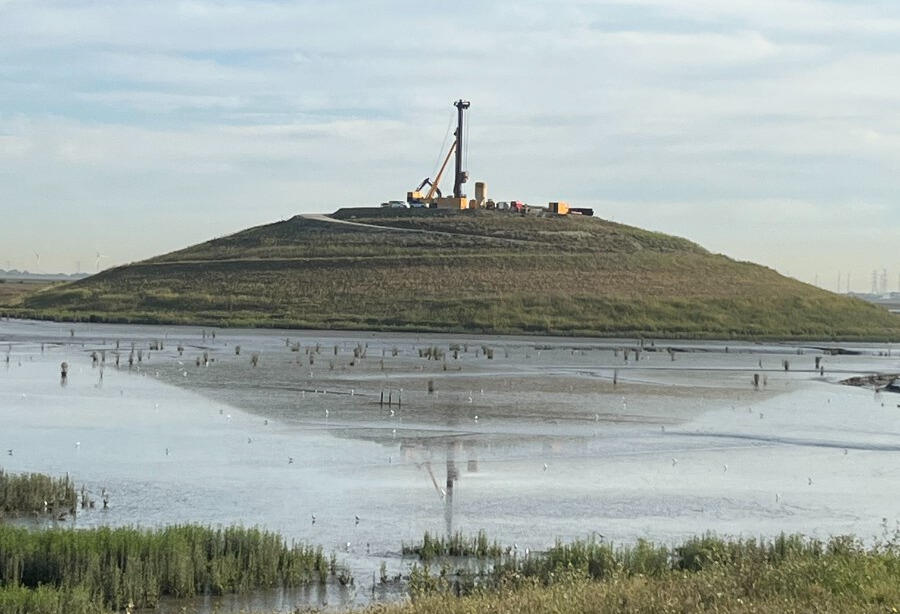 Heuvel in slikkengebied waar kranen starten met de fundering voor een Panoramatoren.